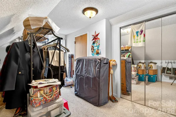 a view of walk in closet with clothes