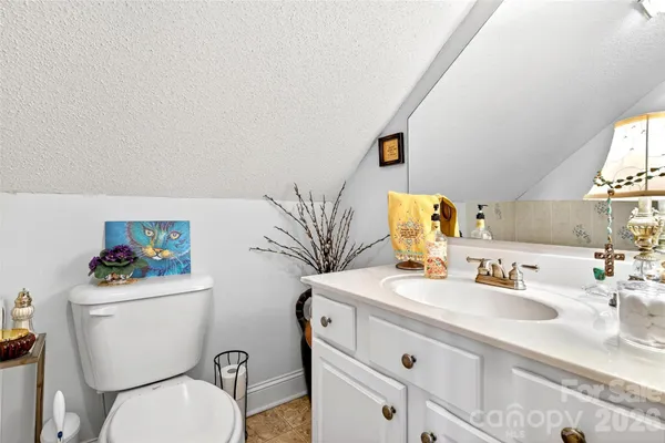 a bathroom with a sink vanity mirror and toilet