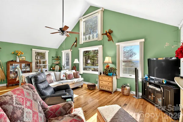 a living room with furniture a flat screen tv and a floor to ceiling window