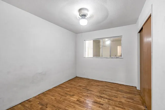 a view of empty room with wooden floor