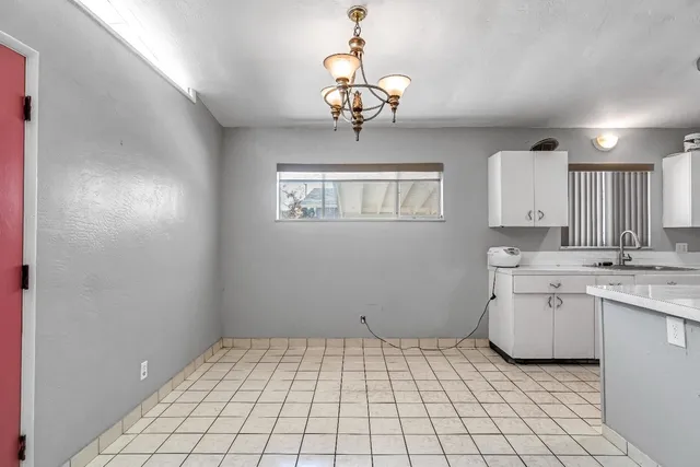 a room with a chandelier fan and window