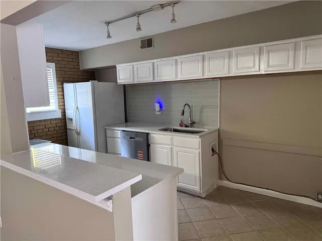 a kitchen with refrigerator and cabinets