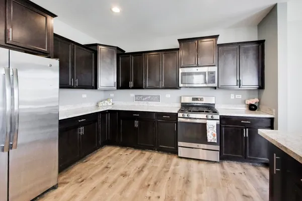 a kitchen with stainless steel appliances granite countertop a refrigerator and a stove top oven
