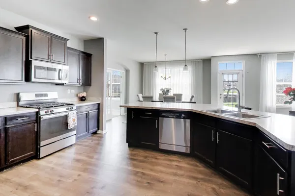 a kitchen with stainless steel appliances granite countertop a sink a stove and cabinets