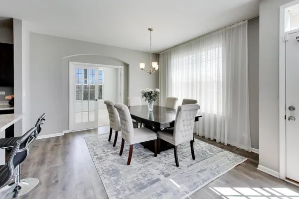 a view of a a dining room with furniture window and wooden floor