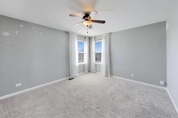 a view of an empty room with a ceiling fan
