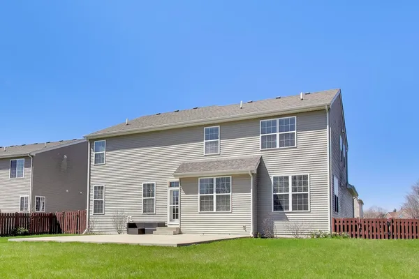 a view of an house with backyard and a tree