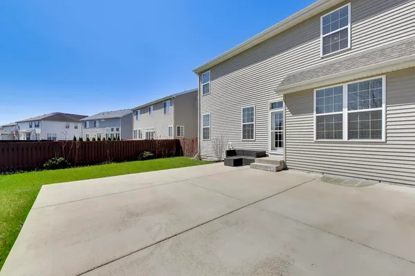 a backyard of a house with table and chairs