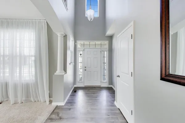 a view of a hallway with wooden floor and closet area