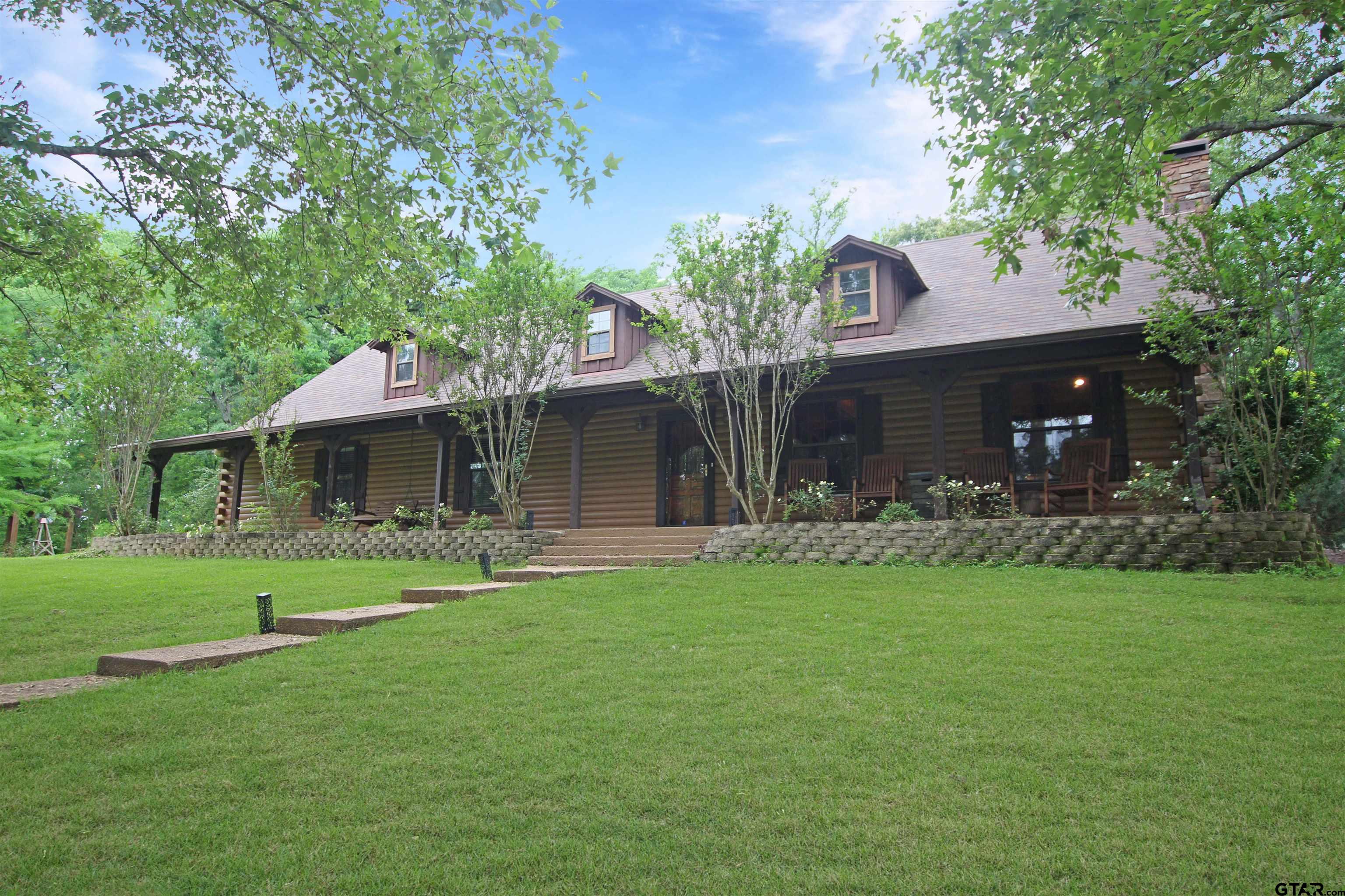 782 Rosie Wady Road Gladewater, TX 75647 - Photo 2 of 48 a front view of a house with a garden and trees