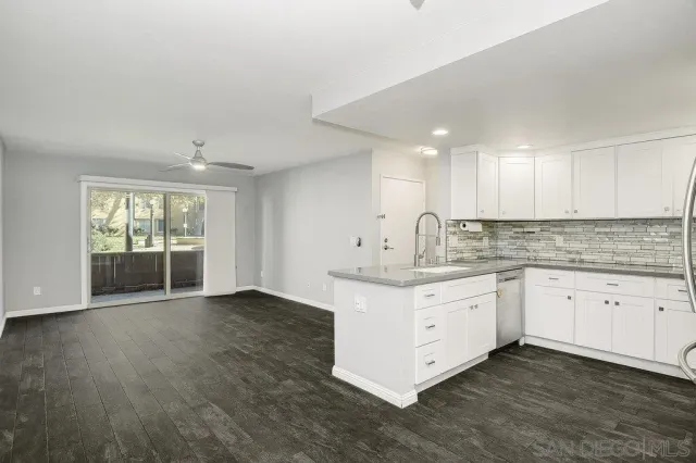 a kitchen with granite countertop white cabinets and white appliances