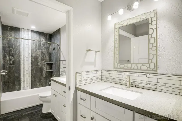 a bathroom with a sink a toilet and a large mirror