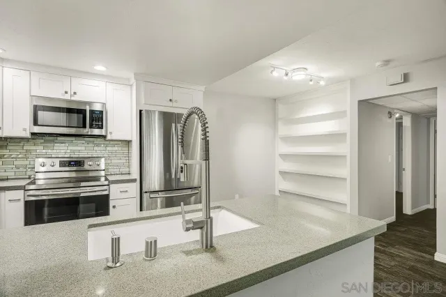 a kitchen with stainless steel appliances a stove sink and microwave