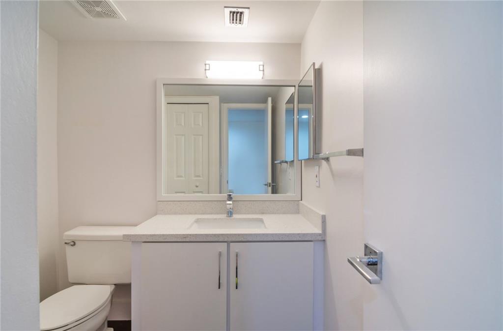 491 Racquet Club Road, Unit 212 Weston, FL 33326 - Photo 18 of 27 a bathroom with a sink a toilet and mirror