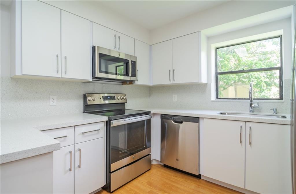 491 Racquet Club Road, Unit 212 Weston, FL 33326 - Photo 2 of 27 a kitchen with granite countertop white cabinets and white appliances