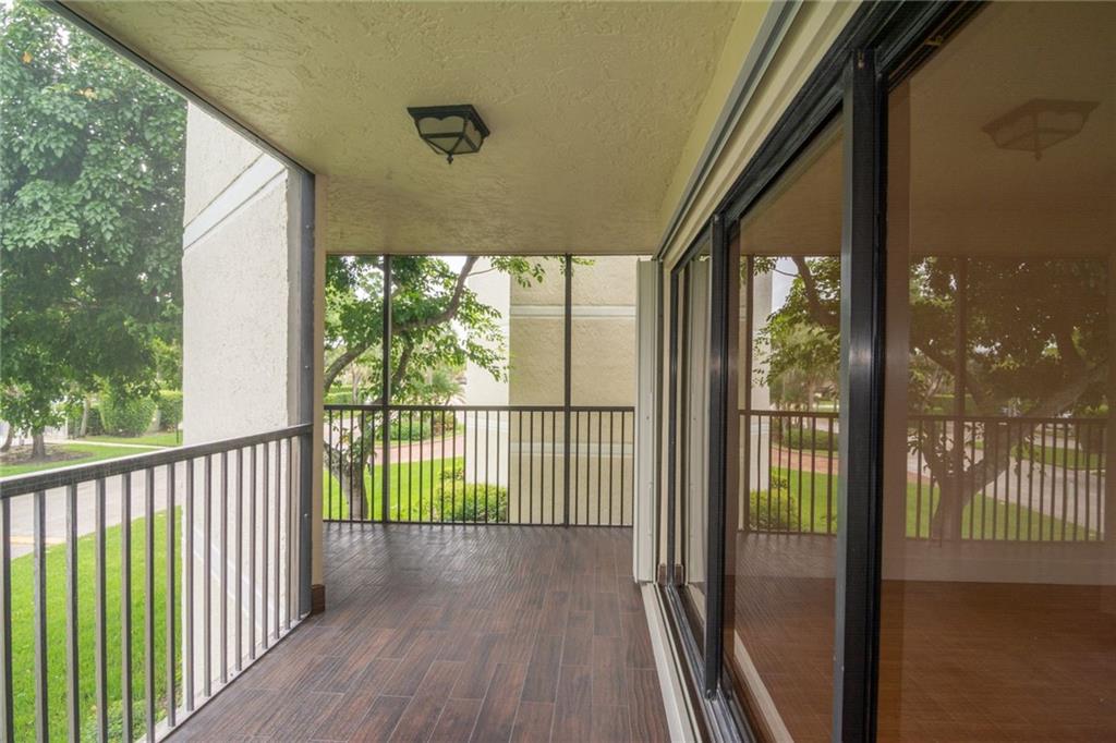 491 Racquet Club Road, Unit 212 Weston, FL 33326 - Photo 23 of 27 a view of a porch with wooden floor and stairs
