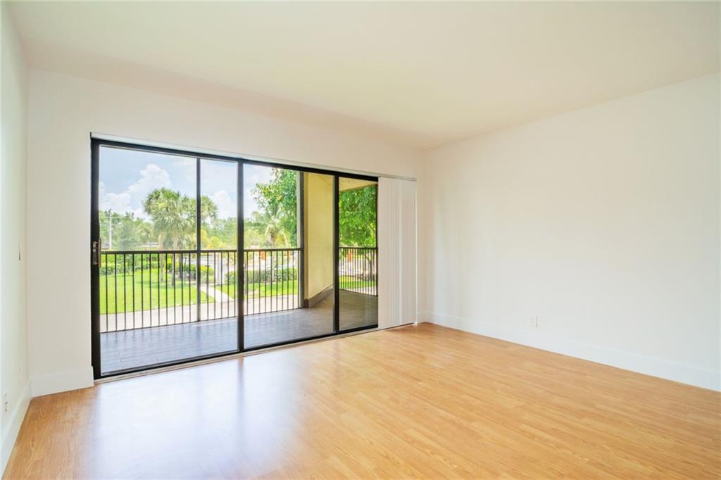 491 Racquet Club Road, Unit 212 Weston, FL 33326 - Photo 3 of 27 a view of an empty room with wooden floor and a window