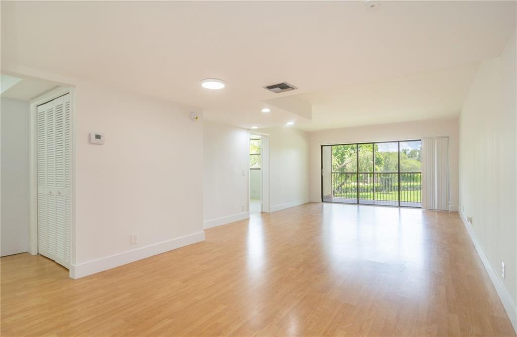 491 Racquet Club Road, Unit 212 Weston, FL 33326 - Photo 4 of 27 a view of an empty room with wooden floor and a window
