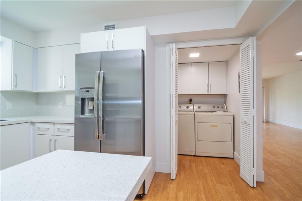 491 Racquet Club Road, Unit 212 Weston, FL 33326 - Photo 7 of 27 a kitchen with a refrigerator a stove and white cabinets