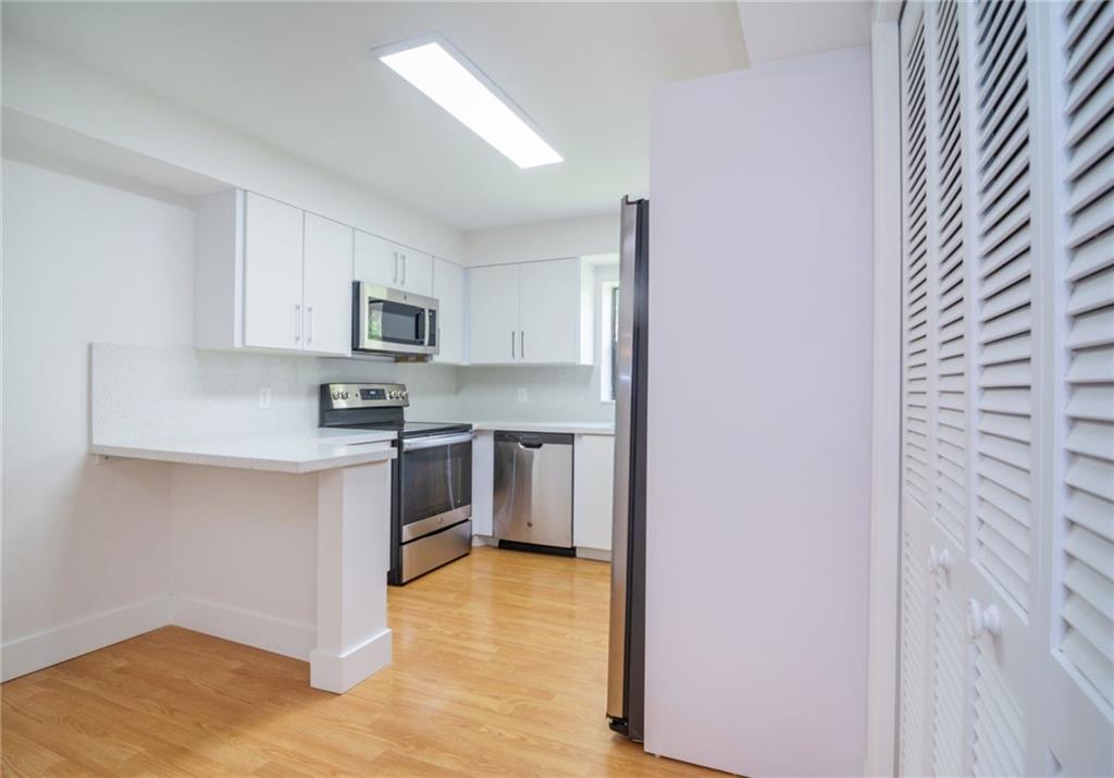 491 Racquet Club Road, Unit 212 Weston, FL 33326 - Photo 8 of 27 a kitchen with stainless steel appliances granite countertop a stove a sink and a refrigerator