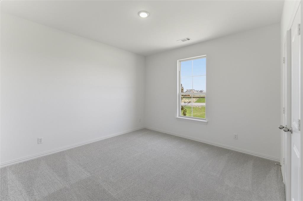 130 Fossil Canyon Drive Rhome, TX 76078 - Photo 13 of 25 Bright interior room with plush grey carpeting and white walls