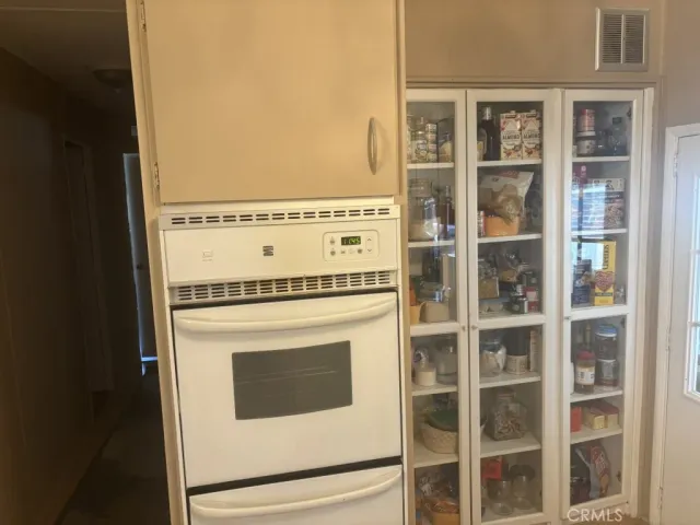 a bed sitting in a bedroom next to a window with a chandelier