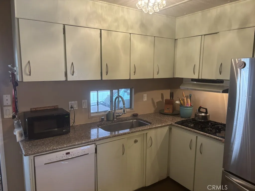 6550 Ponto, Unit 76 Carlsbad, CA 92011 - Photo 19 of 25 a kitchen with stainless steel appliances granite countertop a sink a stove and a refrigerator