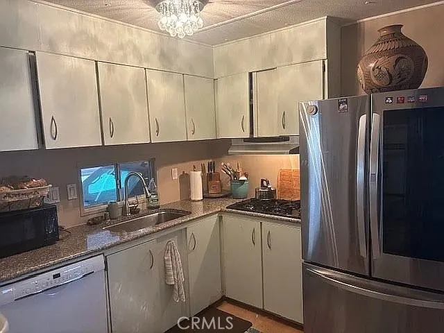 6550 Ponto, Unit 76 Carlsbad, CA 92011 - Photo 20 of 25 a kitchen with stainless steel appliances granite countertop a refrigerator a stove and a sink