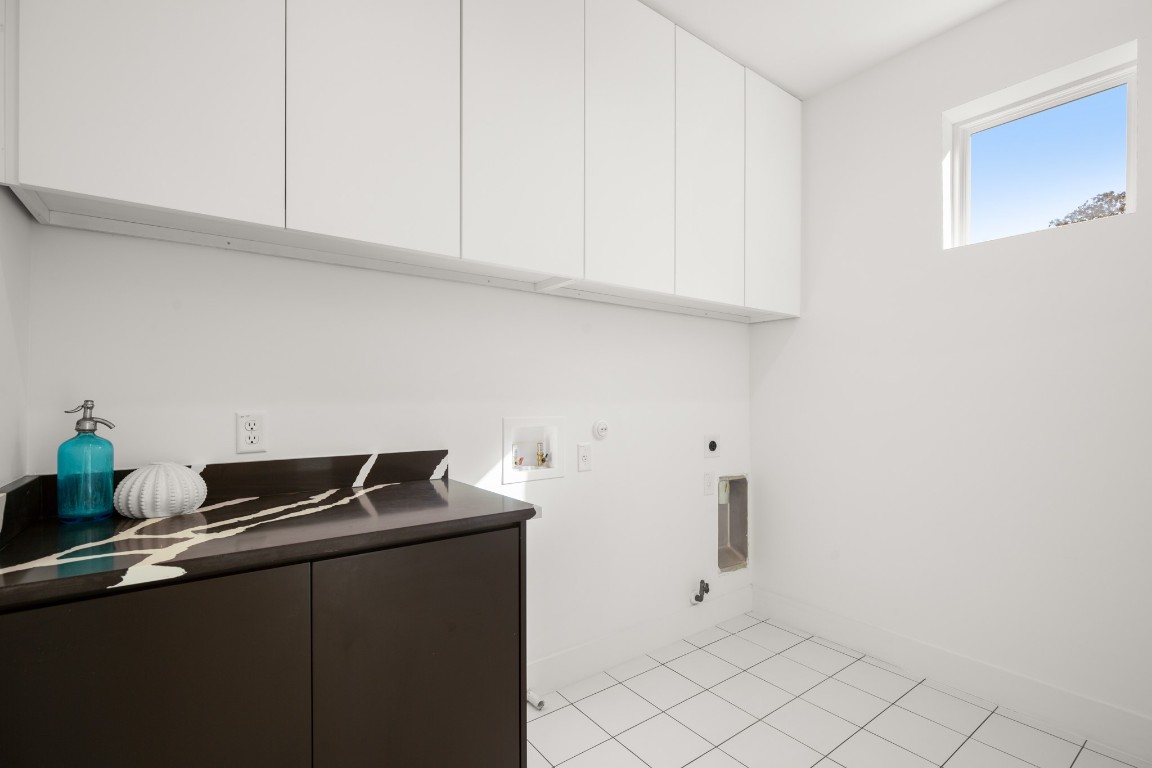 2902 Gonzales Street, Unit 2 Austin, TX 78702 - Photo 20 of 32 Laundry area on the second floor featuring gas dryer hookup, light tile patterned floors, washer hookup, hookup for an electric dryer, and cabinet space