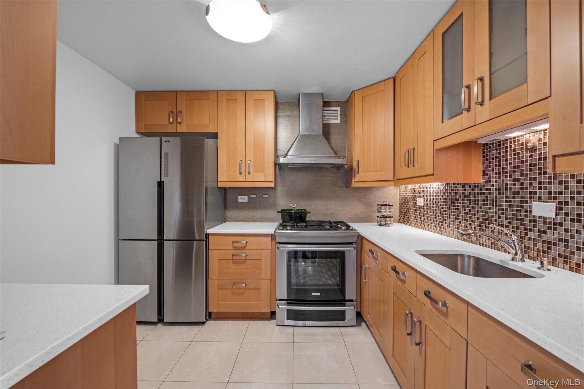 1 Bay Club Drive, Unit 8J Queens, NY 11360 - Photo 6 of 17 a kitchen with stainless steel appliances granite countertop a refrigerator sink and stove