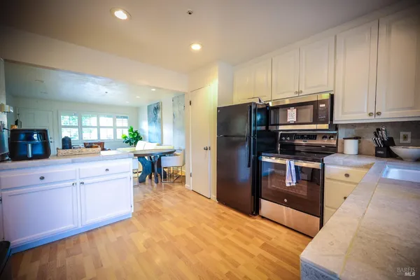 a kitchen with stainless steel appliances a refrigerator and a stove top oven
