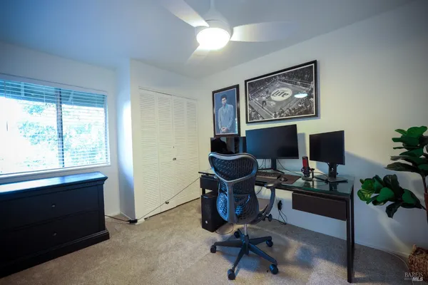 a view of a workspace with furniture and a window