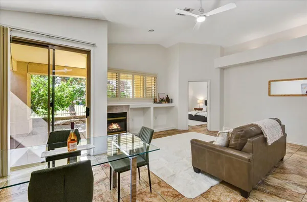 a living room with furniture a fireplace and floor to ceiling windows