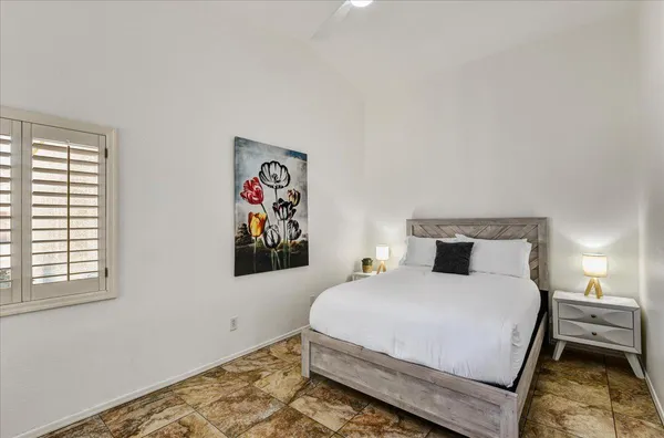 a bedroom with a bed and painting on the wall