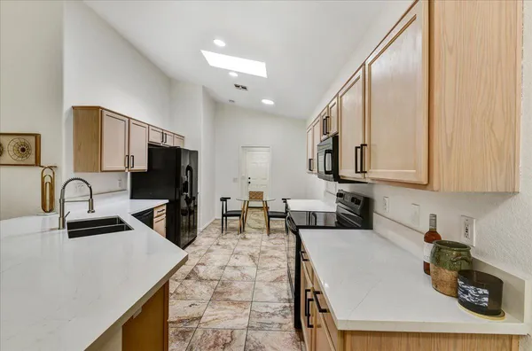 a kitchen with sink a refrigerator and cabinets