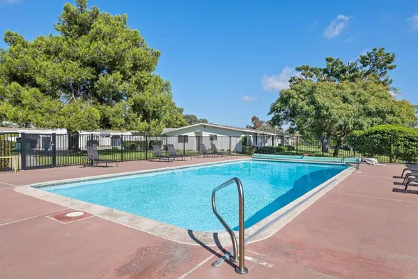 a view of a swimming pool with a patio and a yard