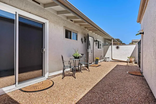 a backyard of a house with table and chairs