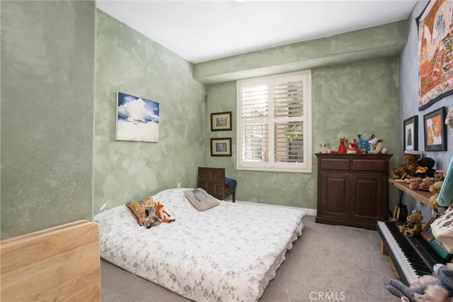 a bedroom with a bed dresser and window