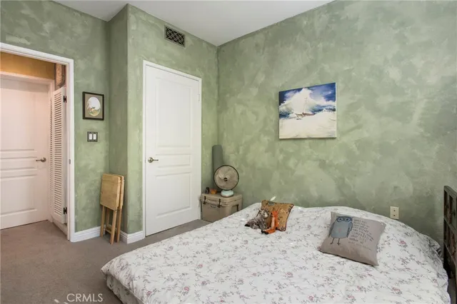 a bedroom with a bed and a painting on the wall