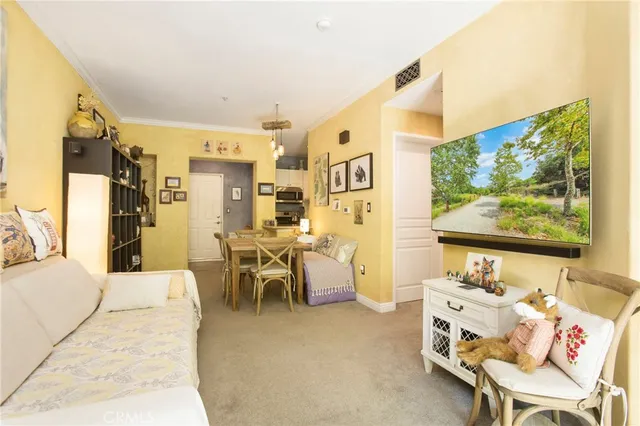 a living room with furniture a flat screen tv and a wall painting