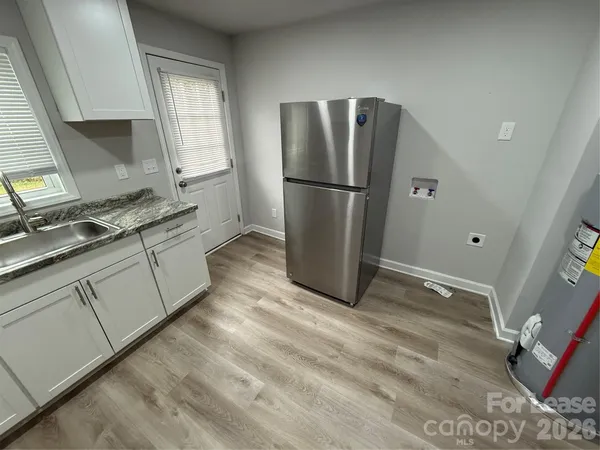 a kitchen with a refrigerator sink and cabinets