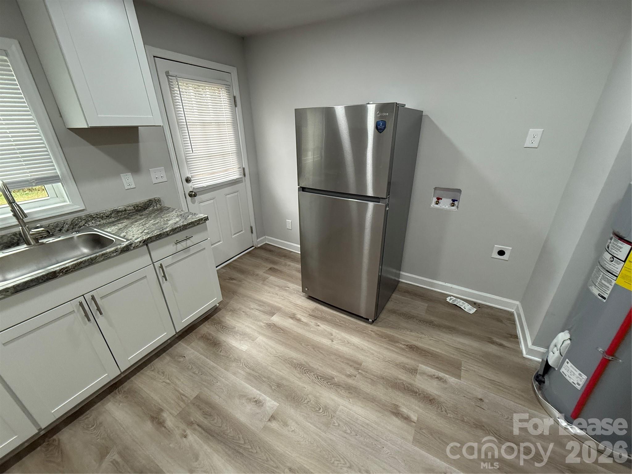 705 North Main Street Stanley, NC 28164 - Photo 5 of 10 a kitchen with a refrigerator sink and cabinets