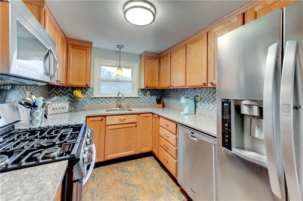 5618 Aiken Road McKees Rocks, PA 15136 - Photo 8 of 22 a kitchen with stainless steel appliances granite countertop a sink stove refrigerator and cabinets