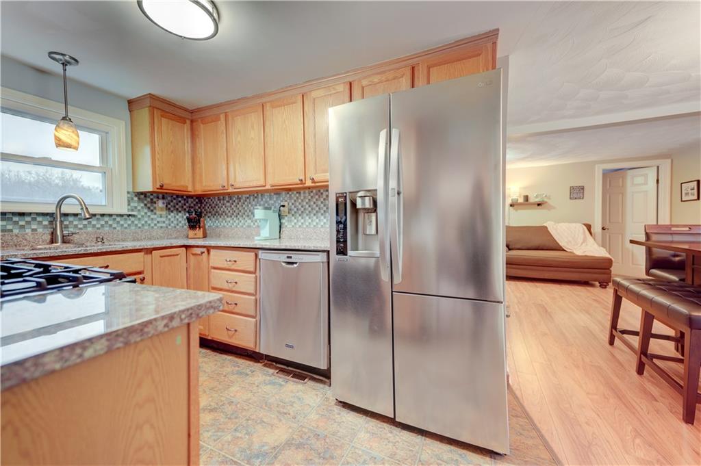 5618 Aiken Road McKees Rocks, PA 15136 - Photo 9 of 22 a kitchen with stainless steel appliances granite countertop a refrigerator a sink dishwasher a stove with wooden cabinets and floor