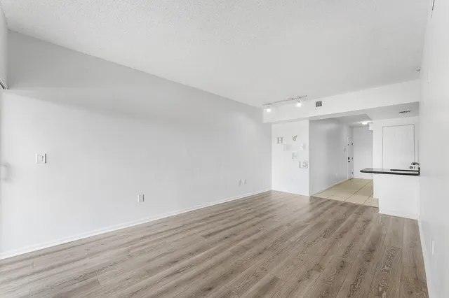 a view of an empty room with wooden floor