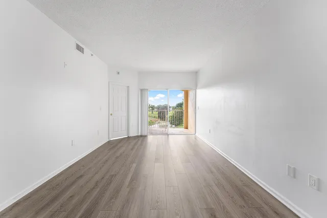 a view of a big room with wooden floor and fireplace