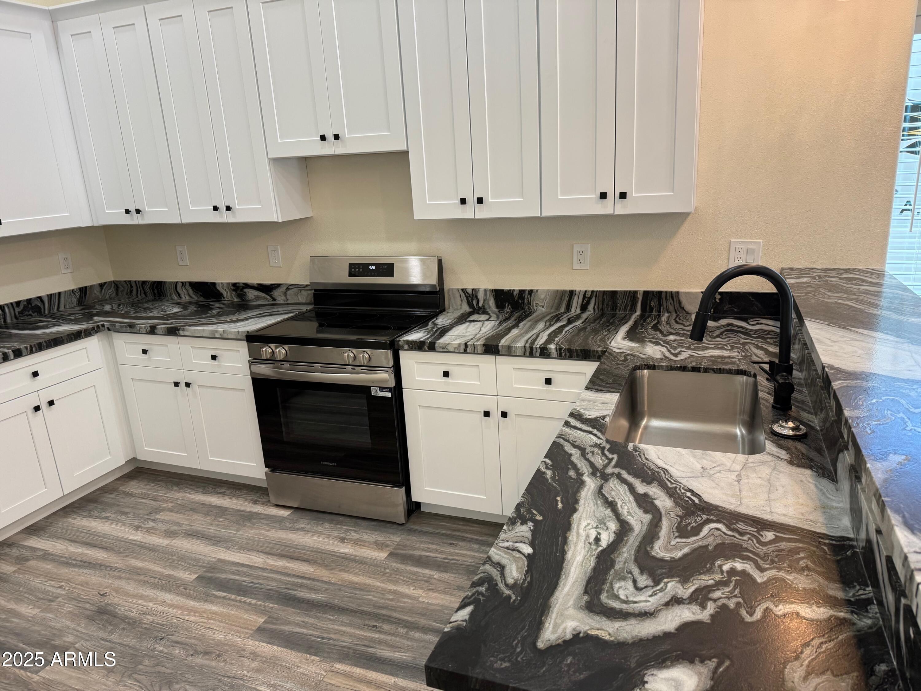 217 West Estate Lane Payson, AZ 85541 - Photo 3 of 8 a kitchen with a stove and white cabinets