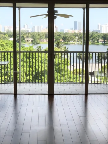 a view of empty room with wooden floor and floor to ceiling window