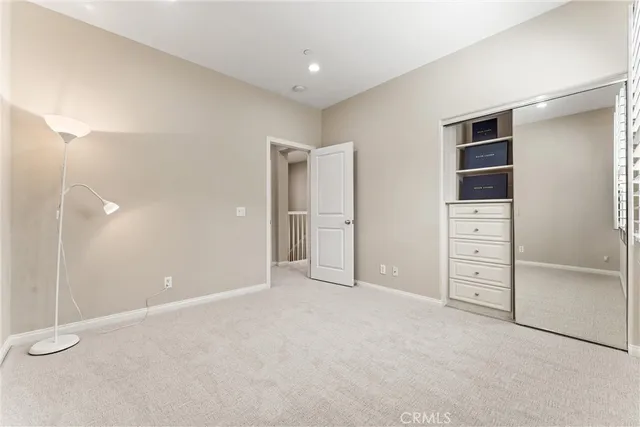 a view of an empty room with closet and entryway