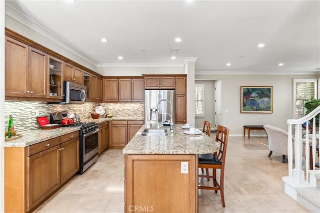 a kitchen with stainless steel appliances granite countertop a stove top oven a sink a stove a dining table and chairs